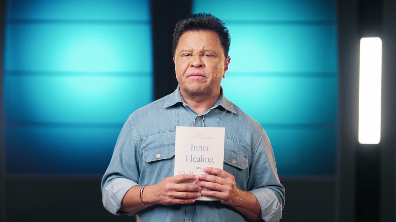 Apostle Guillermo Maldonado holding the book Inner Healing and Deliverance